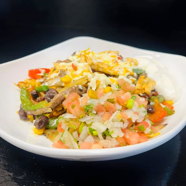 Los Amigos' Mexican dish with steak, peppers, beans, corn, cheese, and pico de gallo.
